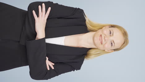 Vertical-video-of-Business-woman-with-arms-folded-and-laughing-at-camera.